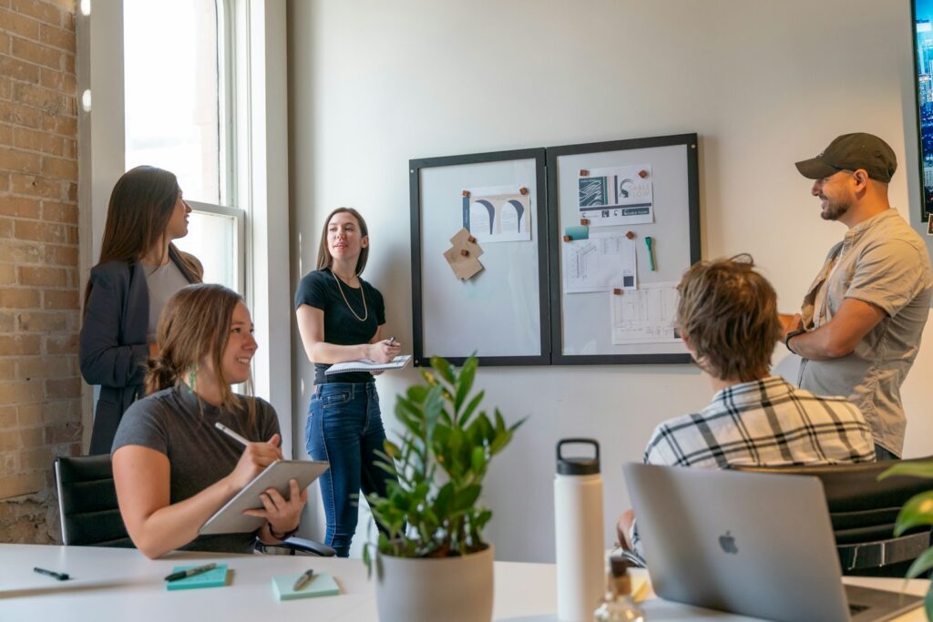 Team in overleg rond een whiteboard in een licht kantoor